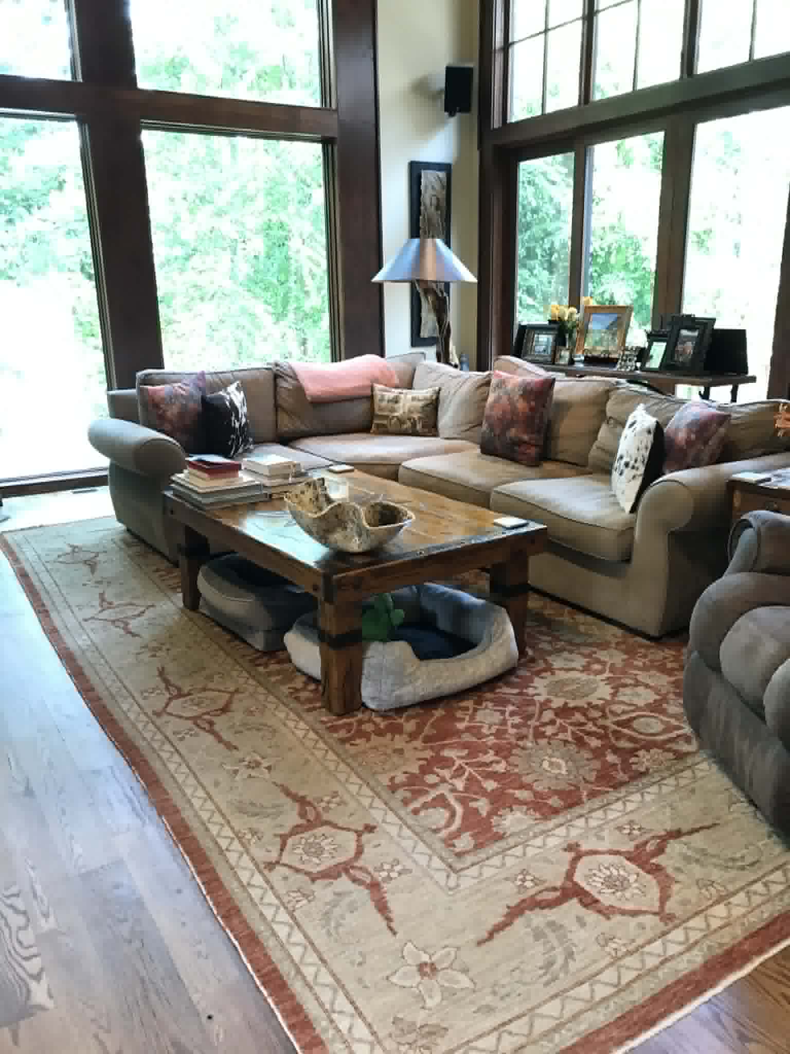 Large open living room with beige sectional and Persian rug