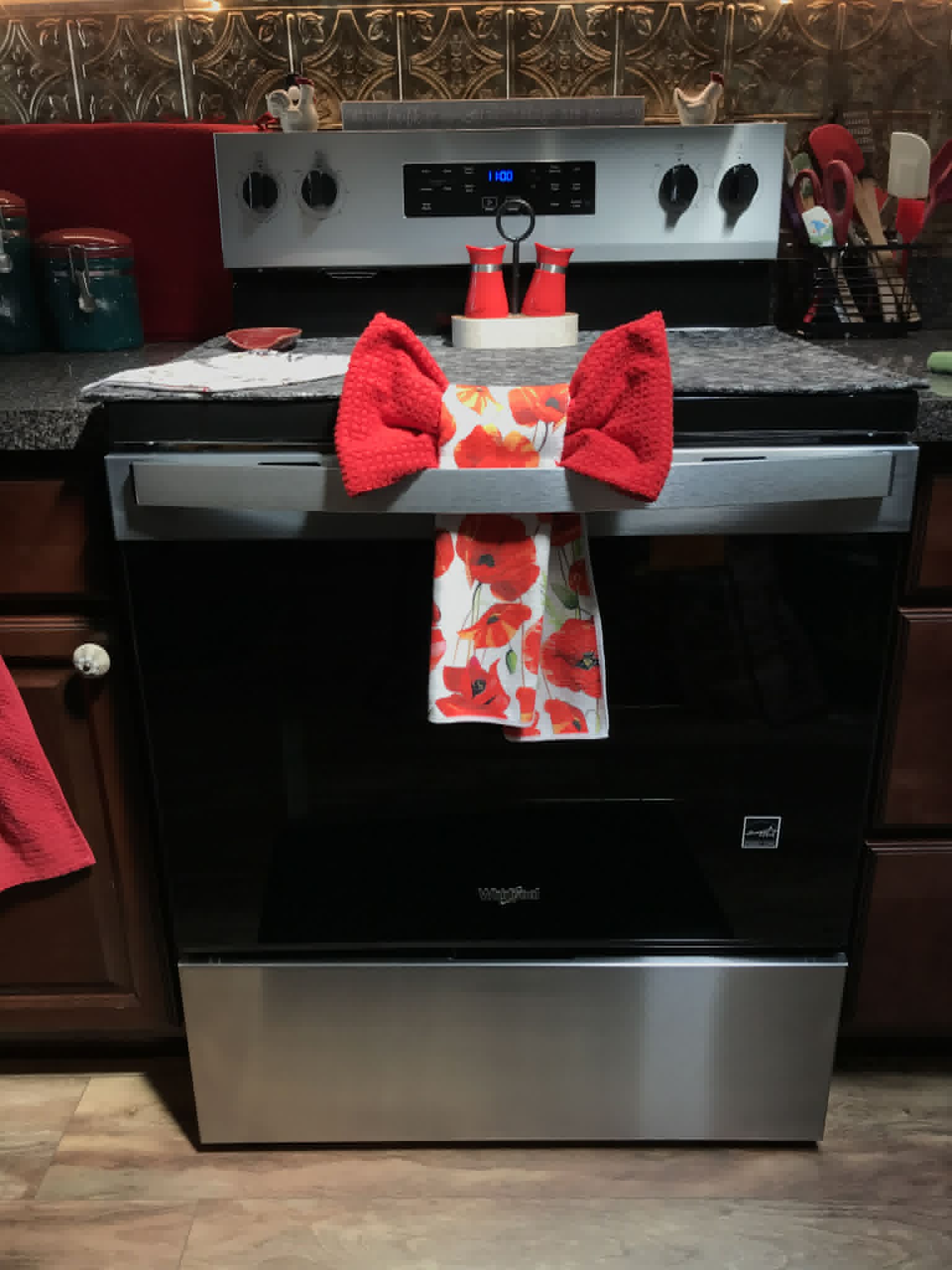 Clean whirlpool electric range with red kitchen accessories