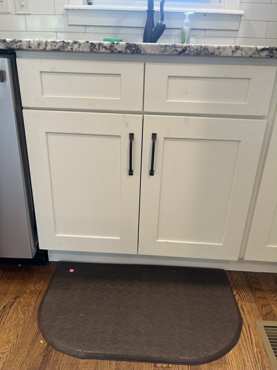 Clean white kitchen under-sink cabinets